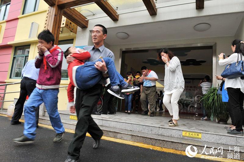 地震突发，老师迅速抱起学生撤离现场